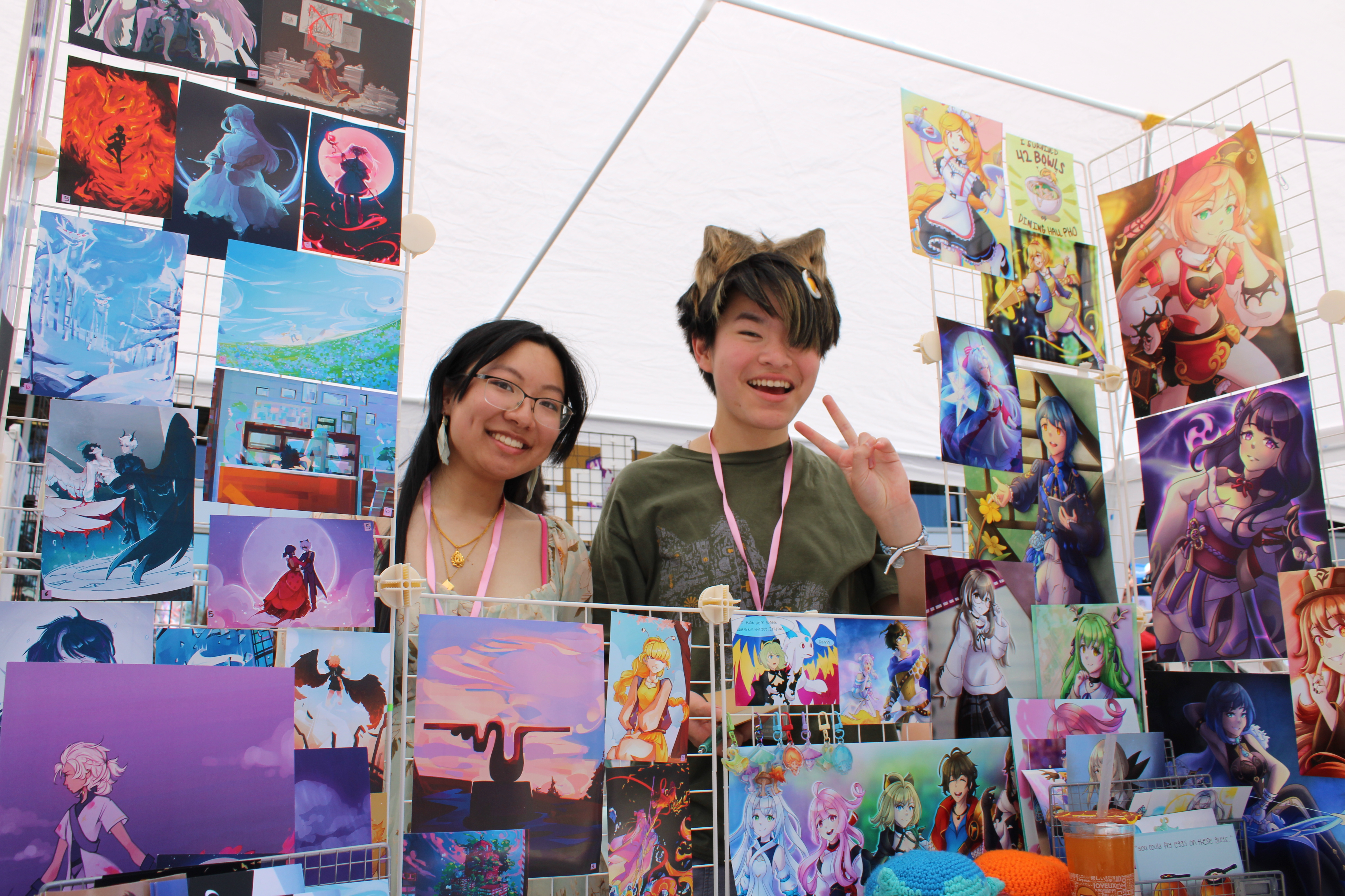 two artists smiling at the camera from their booth