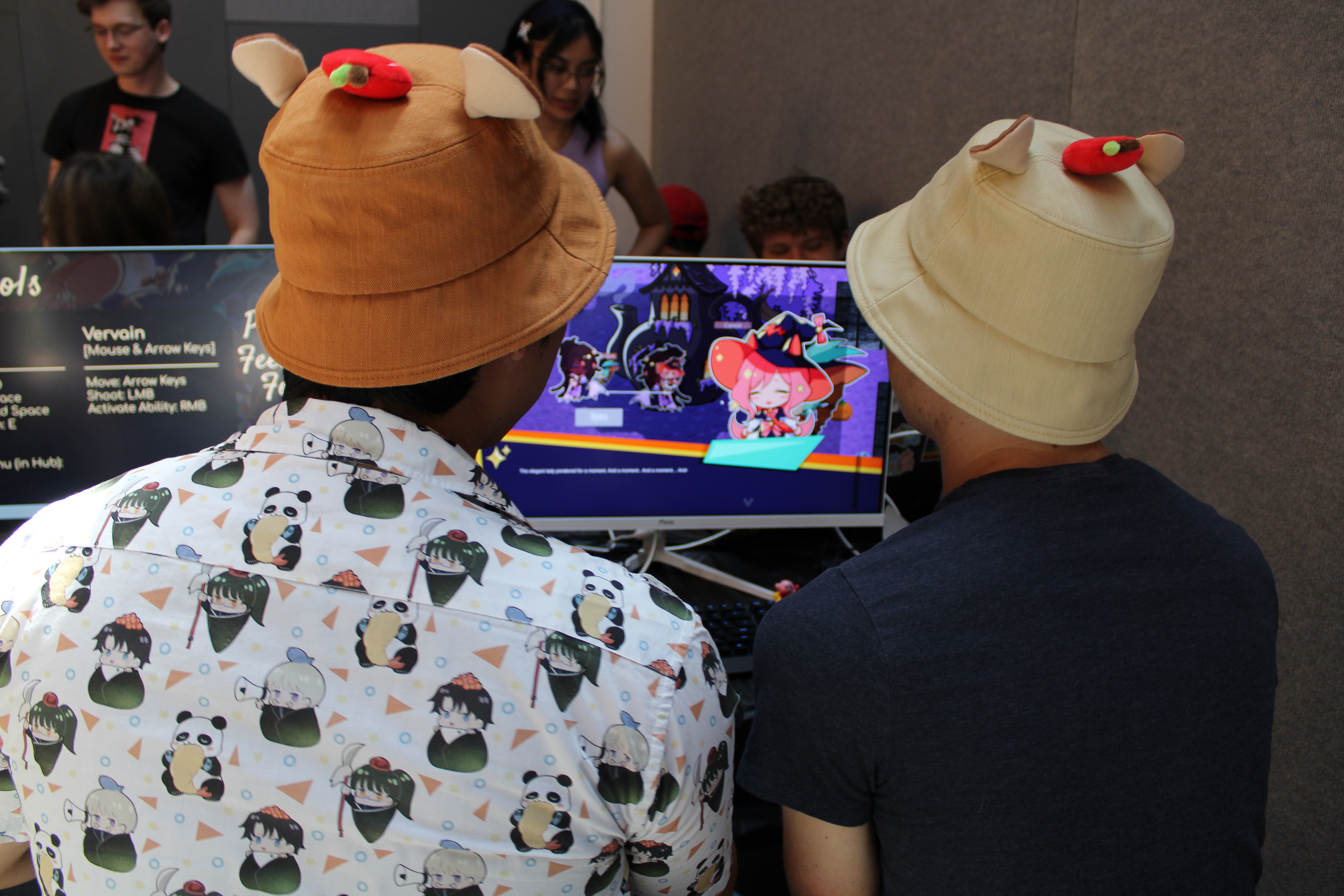 a shot from behind two people playtesting a video game on a monitor
